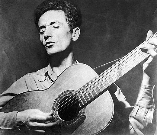 Woody-Guthrie-playing-guitar-520